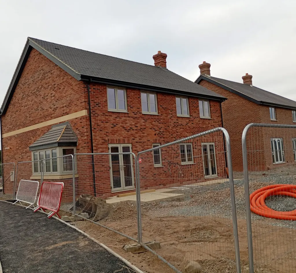Pair of two-storey brick homes with chimneys, a buff stone band and a tiled bay window, a new footpath in front